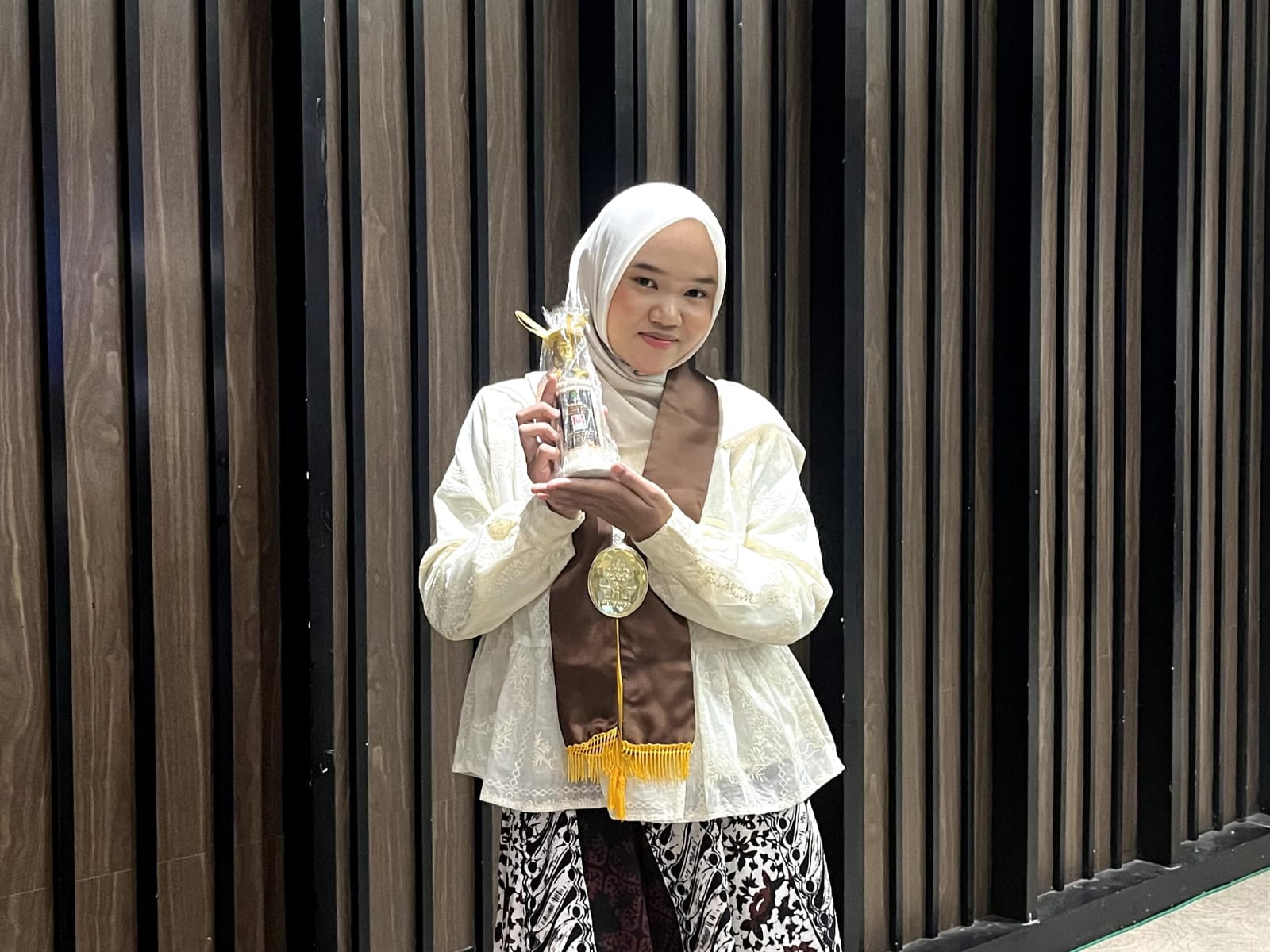 [Wisudawan terbaik] prodi Pengembangan Masyarakat Islam (PMI) UIN Walisongo Semarang, Fairuz Miksalmina, berfoto membawa vandel penghargaan usai prosesi wisuda S1 periode ke-100 di Semarang, Sabtu (23/5). (Foto: LPMMISSI.COM/Dok. Pribadi Fairuz)